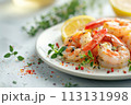 Freshly grilled shrimp adorned with herbs, sprinkled spices, and lemon accents on white plate 113131998