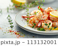 Grilled shrimp adorned with thyme and lemon on a plate, showcasing the vibrant colors and freshness of the dish. 113132001