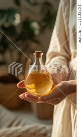 A person is holding a bottle of lotion in their hand. skincare and cosmetic concept. 113132251