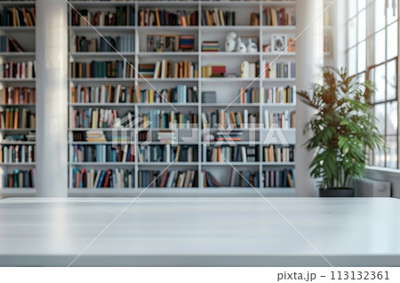 A white room with a wooden table and a shelf full of books 113132361