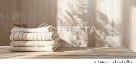 A stack of white towels on a wooden shelf 113132365