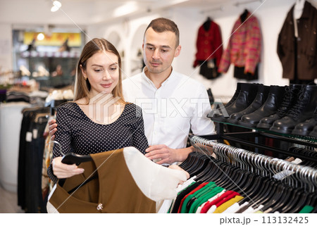 Man with wife participate in inspection of goods, help determine choice of blouse Man with wife participate in inspection of goods, help determine choice of blouse 113132425