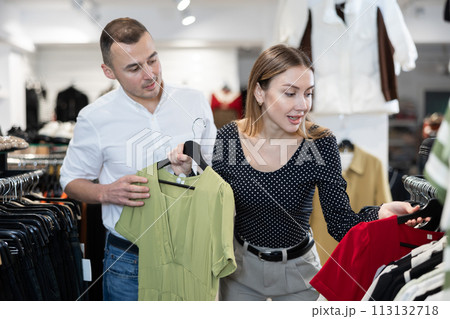 Man with wife participate in inspection of goods, help determine choice of dress Man with wife participate in inspection of goods, help determine choice of dress 113132718