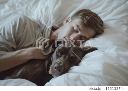 A man is sleeping with his dog on a bed A man is sleeping with his dog on a bed 113132744