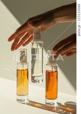 Three bottles of perfume are displayed on a white table Three bottles of perfume are displayed on a white table 113133088