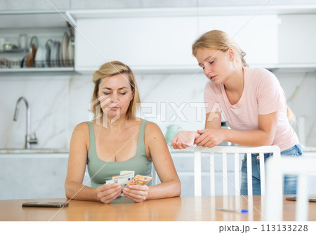 Mother gives teenage daughter bills small amount of pocket money. 113133228