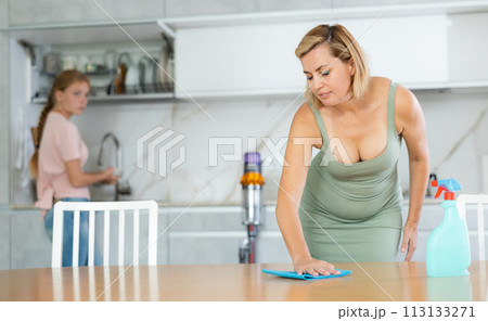 Woman engaged in household cleaning together with teenage daughter 113133271