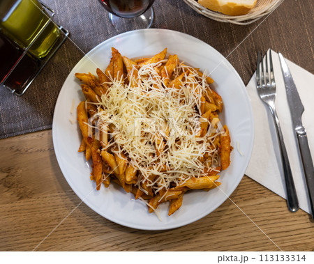 Pasta bolognese with cheese served on platter 113133314