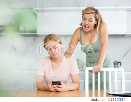 Mother scolds teenage girl for wasting time and sticking in phone. Gadgets and family 113133344