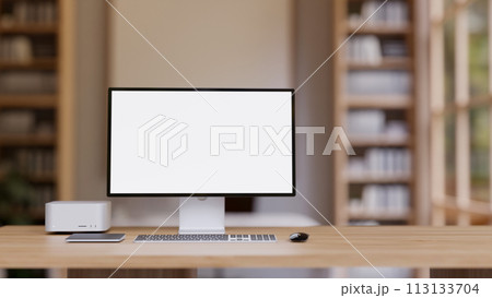 A wooden table features a PC computer mockup, a computer desk in a contemporary home office. 113133704
