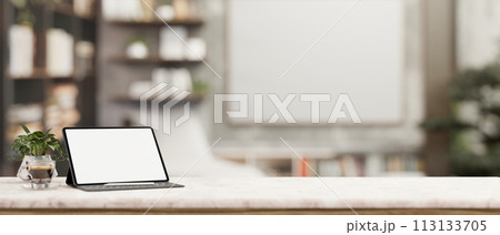 A digital tablet white-screen mockup on a white marble tabletop in a contemporary office room. 113133705