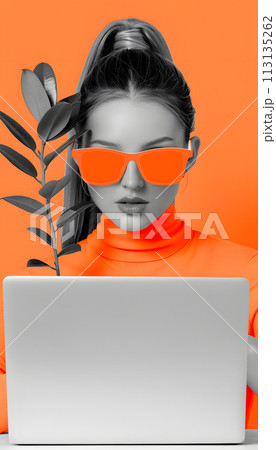 A woman with orange sunglasses is using a laptop computer 113135262