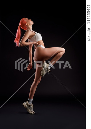 Dynamic photo of sporty woman in sportwear running ahead 113135491
