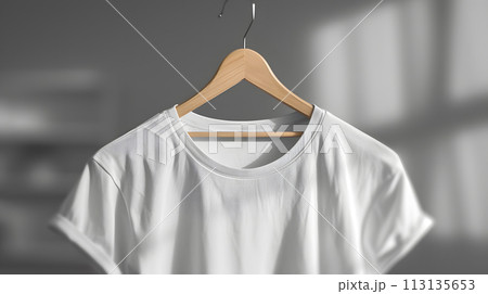 a white tshirt is hanging on a wooden hanger 113135653