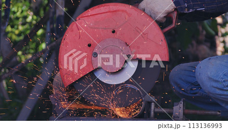 Hot flame welding metal work cutting fire iron workshop. Welding machine iron metal sparking. Locksmith using Welding machine cutting metal processing grinder. Close up hands Sparks in metalworking 113136993