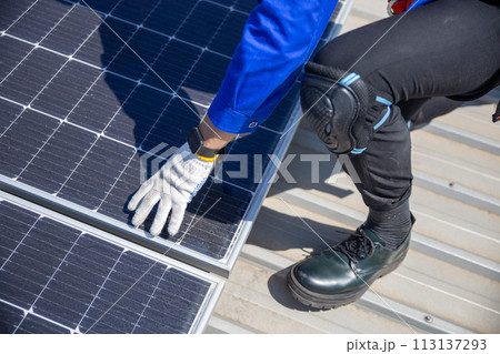 Technicians are installing and inspecting standards of solar panels on roof of an industrial. Technicians are installing and inspecting standards of solar panels on roof of an industrial. 113137293