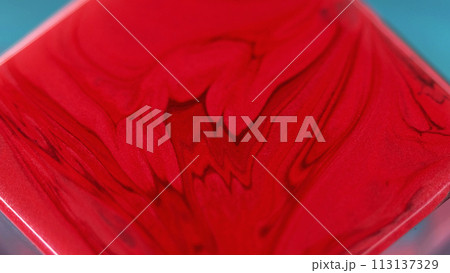 Liquid paint background. Smooth flow. Red burgundy dye mix with glitter particles abstract creative waves motion on square surface in captivating fantasy art. 113137329