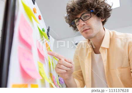 businessman working pointing post it sticky notes information on glass board at office. planning and strategy meeting presentation project. businessman working pointing post it sticky notes information on glass board at office. planning and strategy meeting presentation project. 113137628