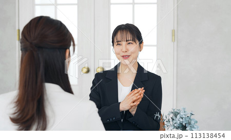 オフィスで会話する二人の女性 113138454