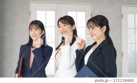 笑顔でオフィスに並ぶ三人のビジネスウーマン 113138468