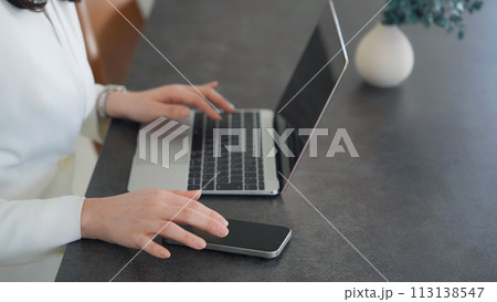 ノートパソコンとスマホを使う女性 113138547