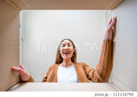 Low angle view of surprised young asian woman unpacking 113138799