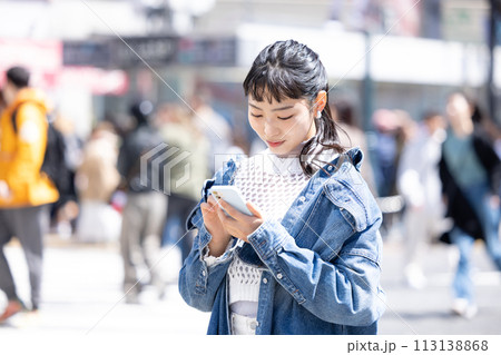 ストリートスナップ　街中でスマホを見ている若い女性 113138868