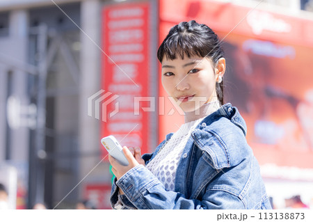 ストリートスナップ 街中でスマホを見ている若い女性 ストリートスナップ 街中でスマホを見ている若い女性 113138873