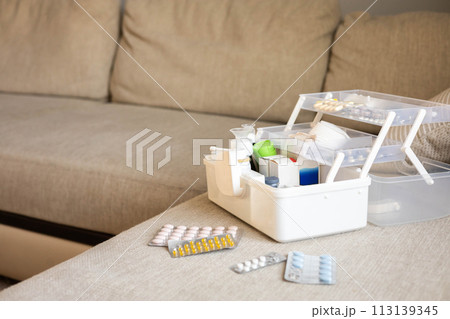 Closeup female hand placing medicament domestic first aid kit. Storage organization emergency supply 113139345