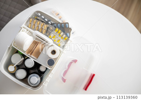 Closeup female hand placing medicament domestic first aid kit. Storage organization emergency supply 113139360