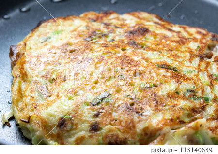 お好み焼きをフライパンで焼く調理シーン。 113140639