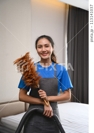 Portrait of female cleaning service worker holding duster and looking at camera Portrait of female cleaning service worker holding duster and looking at camera 113141037