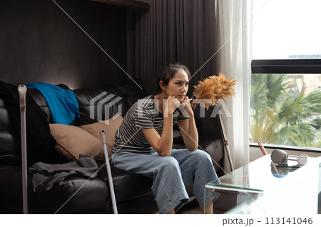 Tired and unhappy young female housewife taking a break from cleaning home 113141046