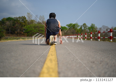 Low angle view of sportsman in low starting position preparing for run 113141127