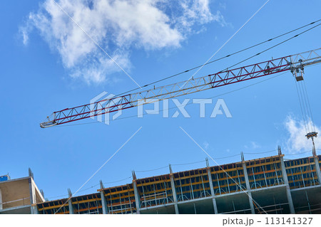 Large construction high rise crane, clear blue sky 113141327