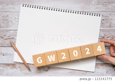 GW2024と書かれたブロック、ノート、ペン、手 113141775