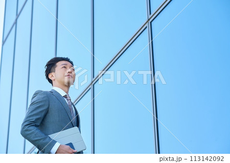 屋外で空を見上げるスーツ姿のビジネスマン 113142092