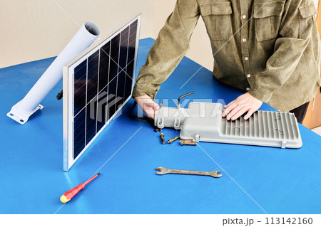Assembling fully autonomous street light on mounting table, attaching solar module and LED lamp to mounting bracket. Assembling fully autonomous street light on mounting table, attaching solar module and LED lamp to mounting bracket. 113142160