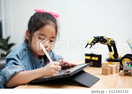 A young girl is playing with a remote control a robot 113143132