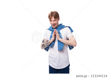young emotional handsome slender red-haired man with a tattoo on his arms is dressed in a stylish 113144114