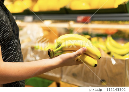 Boy holding a bunch of bananas in the supermarket Boy holding a bunch of bananas in the supermarket 113145502