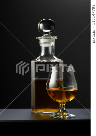 Old decanter and glass with whiskey, cognac or brandy. 113147795