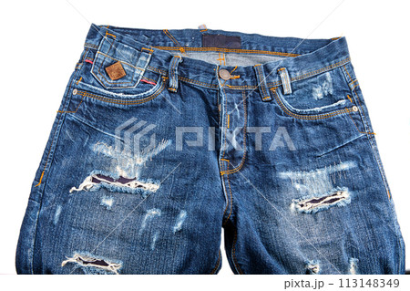 A fragment of blue denim trousers with scuffs on the elements on a white background 113148349