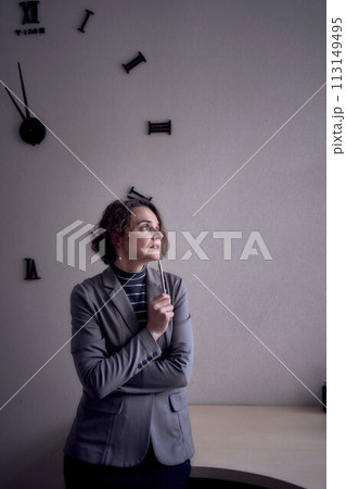 woman standing in office in front of clock 113149495