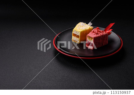 Delicious sweet cheesecake with fruits covered with icing with a wooden stick 113150937
