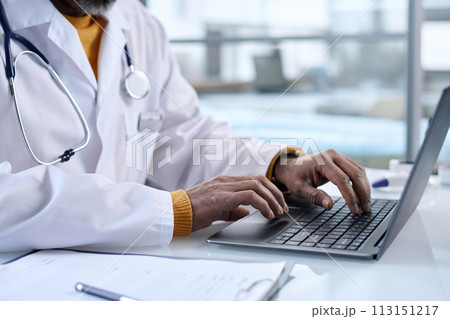 Side view closeup of unrecognizable doctor typing on laptop keyboard at workplace in clinic copy space Side view closeup of unrecognizable doctor typing on laptop keyboard at workplace in clinic copy space 113151217