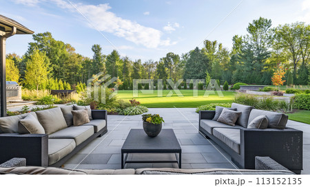Beautiful garden with seating and lush greenery, captured from the perspective of an open door leading to a large patio area 113152135