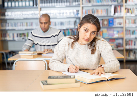 Young adult woman studying in public library 113152691