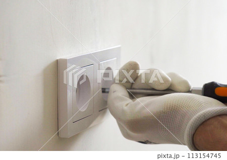 Installation of electric household socket on the wall during the renovation of the apartment 113154745