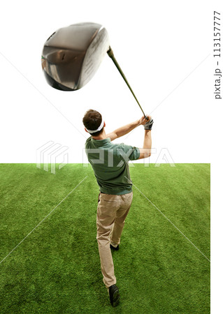 Professional golfer in retro outfit in mid follow-through with focus on club, green turf against white studio background. 113157777